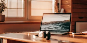 Remote answering service setup with laptop, headphones, and smartphone.